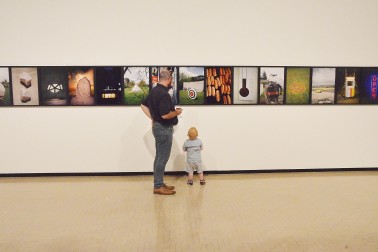 Image of a young boy and his dad looking at art
