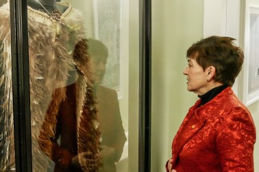 Image of Dame Patsy examining Te Mahutonga, the kakahu worn by our Olympic flag bearer at opening ceremonies