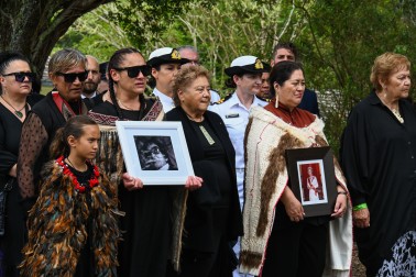 Portraits of Her Late Majesty and Titewhai Harawira are carried onto the marae