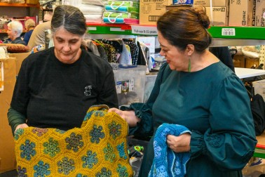 Donna Turtle Sarten, co-founder of Give a Kid a Blanket, and Dame Cindy looking at some of the beautiful crocheted blankets