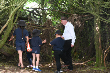 Doctor Davies being shown the children's play hospital at Te One School's wilderness area