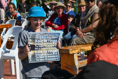 One of the tamariki of Cholmondeley holding the words for a waiata