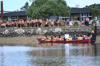 Dame Cindy stands in the waka as students from Te Kapehu Whetu perform a haka on the bank of the river