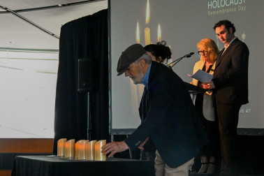 Dov Bing and his grand-daughter light a memorial candle