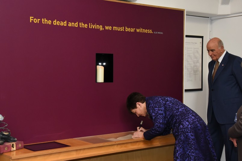 An image of Dame Patsy inscribing a memorial stone