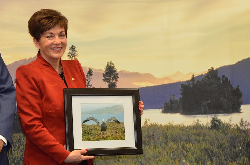an image of Dame Patsy holding a photograph of an endangered Antipodean albatross