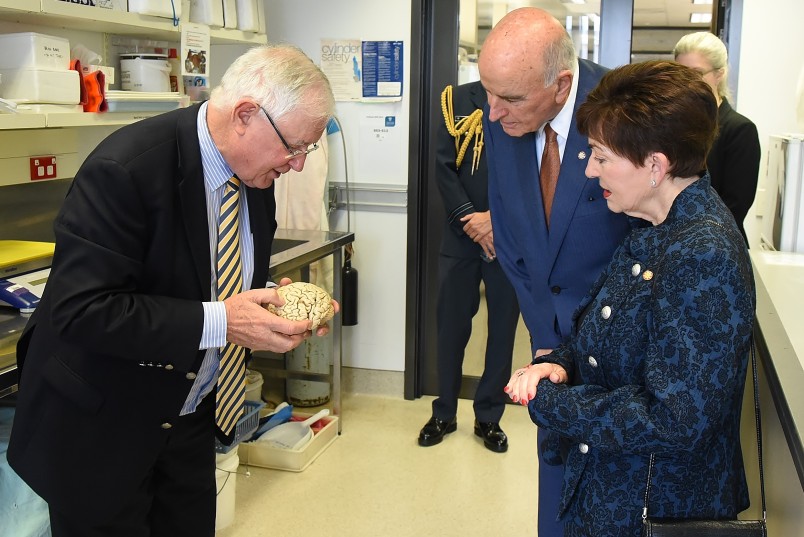 Image of Prof. Sir Richard Faull showing Dame Patsy and Sir David a plastinated human brain
