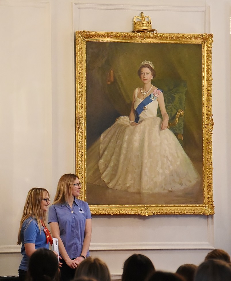 Image of the Queen's Guide award presentation in front of the portrait of the Queen