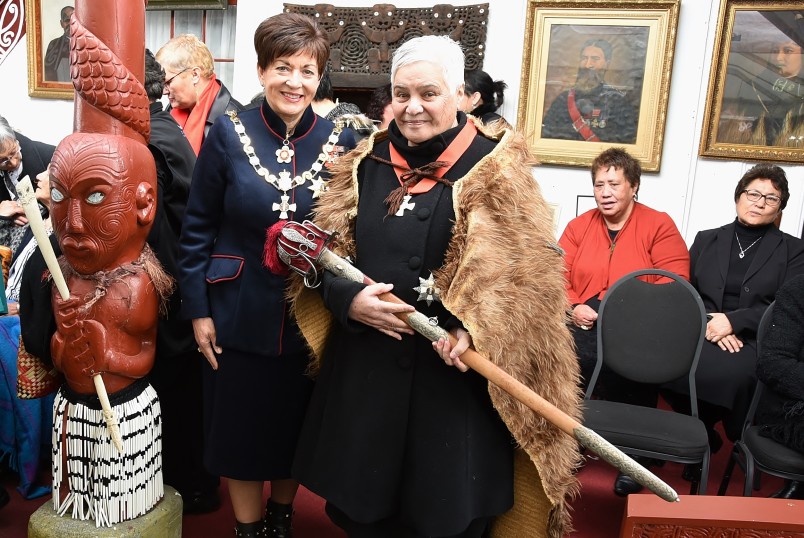 Image of Dame Patsy with Dame Tariana, who is Wearing a cloak and holding the sword of Te Keepa, a link to Queen Victoria