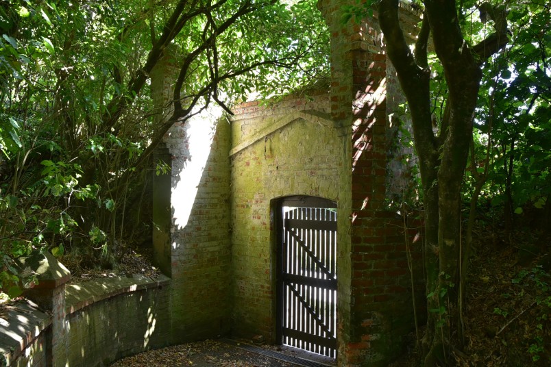 Image contains a brick wall with a wooden gate