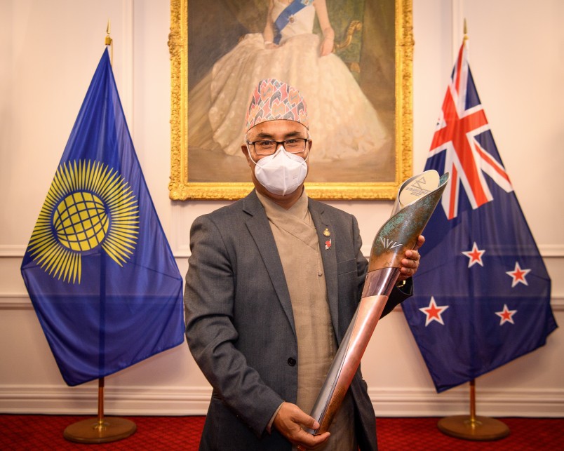A guest holding the Queen's Baton