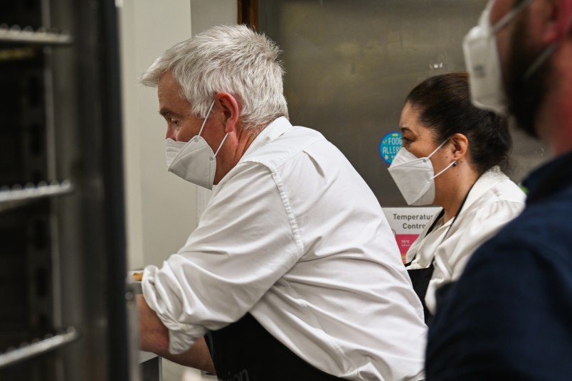 Dr Davies and Dame Cindy serving from the kitchen