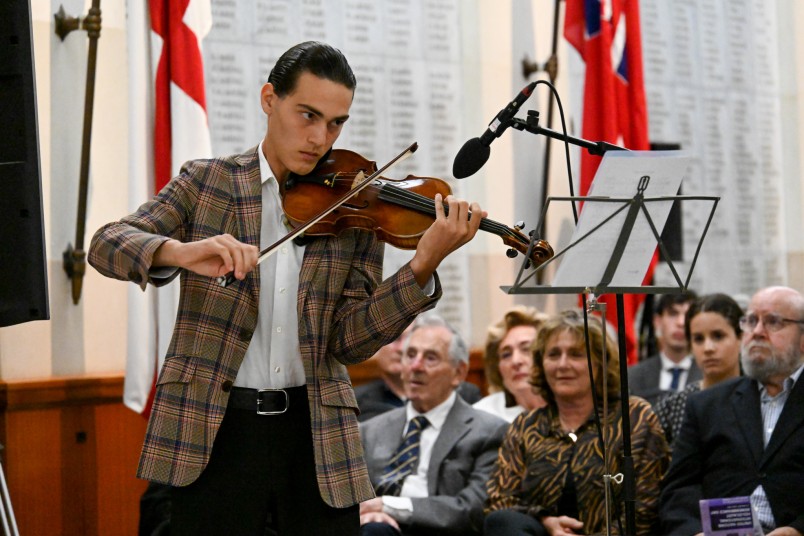 A violinist performing Zog Nit Keyn Mol, Song of the Warsaw Ghetto