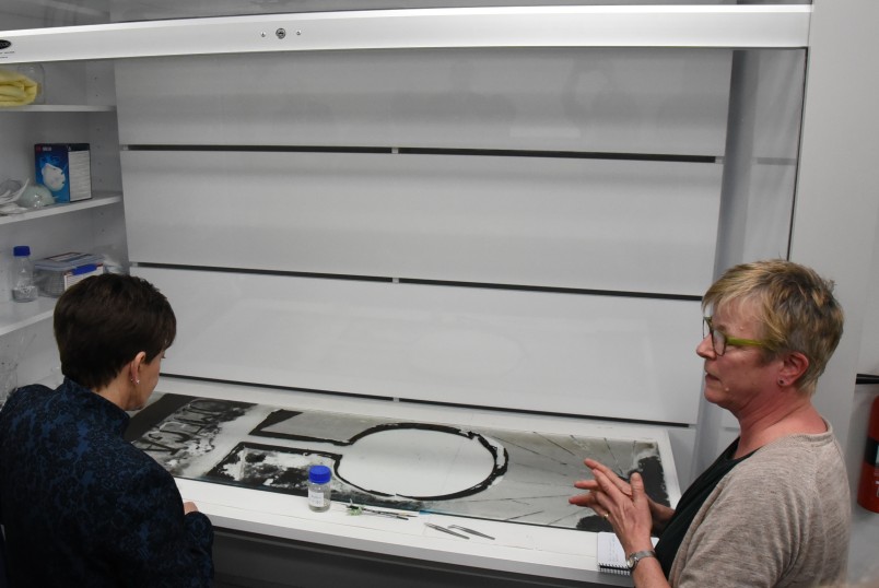 Image of  Dame Patsy and Objects Conservator, Annette McKone discussing the work being done on a Colin McCahon painted glass window