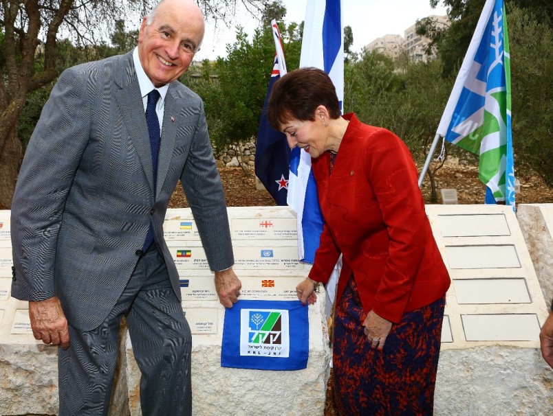 an image of Dame Patsy and Sir David unveil a plaque to mark the planting of an olive tree at the Grove of Nations