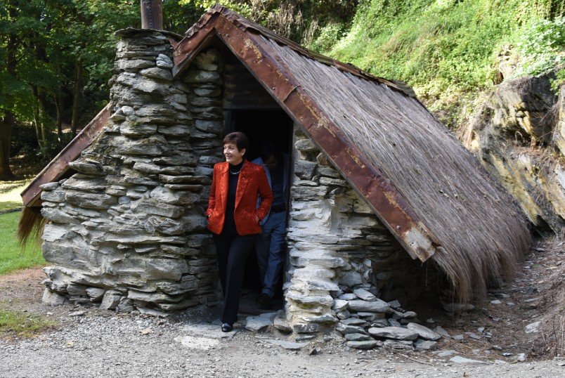 Image of Dame Patsy exiting a miner's hut