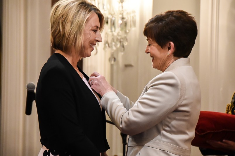 Image of Dame Patsy pinning on Felicity's insignia