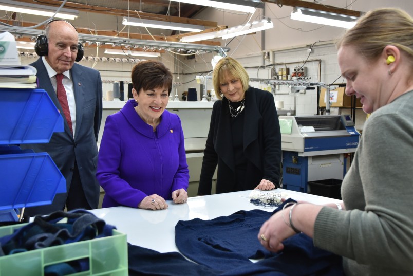 Dame Patsy Reddy and Sir David Gascoigne inspect a garment
