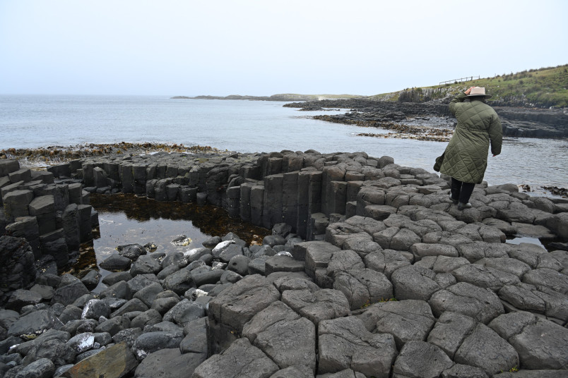 Dame Cindy exploring the basalt columns on Rekohu