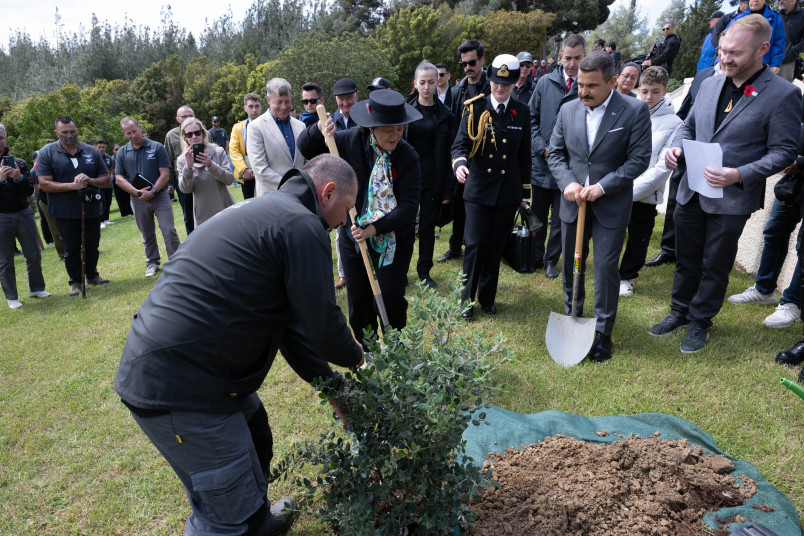 Dame Cindy planting a pōhutukawa at the No. 2 Outpost Cemetery