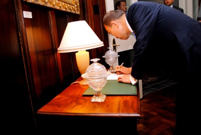 Ban Ki-moon, Secretary-General of the United Nations, writes in the Government House Visitor's Book.