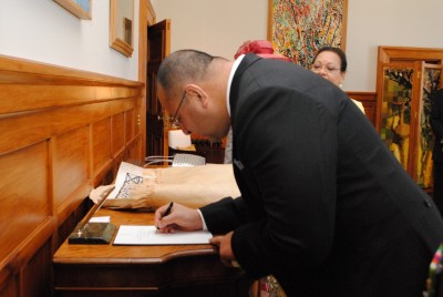 The King of Tonga signs the Government House Visitor Book.