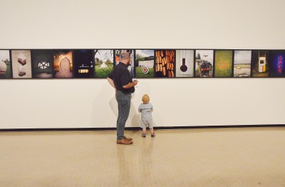 Image of a young boy and his dad looking at art