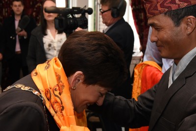 Image of Dame Patsy being presented with Nepalese scarves