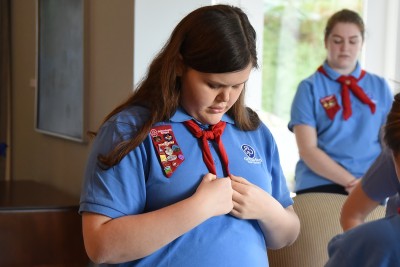 Image of a Girl Guide checking her tie