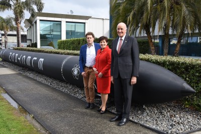 Image of dame Patsy, Sir David and Peter Beck with a rocket outside Rocket Lab