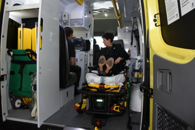 an image of Dame Patsy trying out the patient experience in a top of the range ambulance