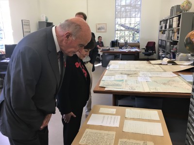 an image of Dame Patsy and Sir David inspecting early letters and maps of New Zealand