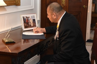 Image of The King of Tonga, King Tupou VI signing the Visitor Book