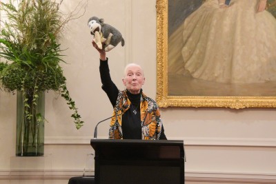 Image of Dr Jane Goodall holding up her chimp mascot Mr H