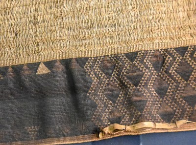 Detail of a large, very finely woven cloak, featuring dog-skin trim