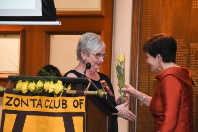 Image of Dame Patsy receiving a Zonta yellow rose from Souella Cumming