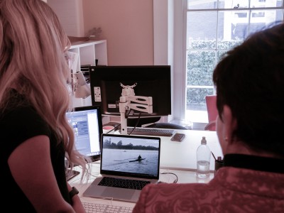 Image of Dame Patsy checking out footage of Mahe Drysdale in action with the Communications and Public Affairs team