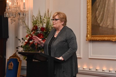 Glenda Hughes speaking at a lectern