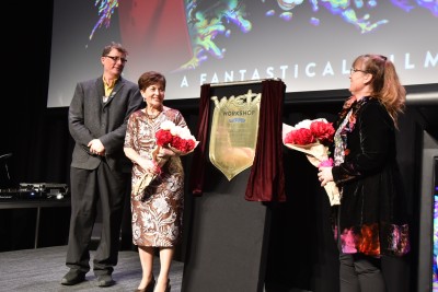 Dame Patsy standing by a plaque, officially opens Weta Unleashed