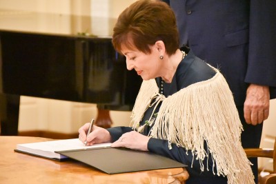 Image of Dame Patsy signing the Visitor Book