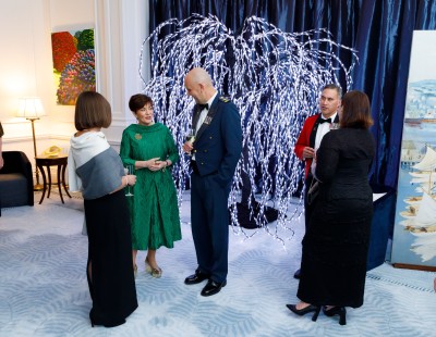 Dame Patsy Reddy with guests by a light up tree