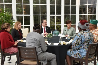 Dame Patsy sits at a table with new Ambassadors and High Commissioners