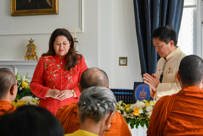 Dame Cindy and Ambassador Pouapinya bow their heads as the monks chant