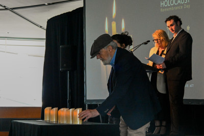 Dov Bing and his grand-daughter light a memorial candle