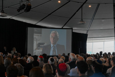 Audience members watch the trailer for the new film From Hate to Holocaust: New Zealand Survivors Speak