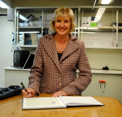 Lady Janine Mateparae signs the HMNZS Resolution Visitor's Book.