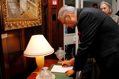 Kamalesh Sharma, Commonwealth Secretary-General, signs the Government House Visitor's Book.